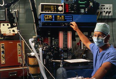 Anaesthetist adjust anaesthetic equipment - Stock Image - M554/0176 - Science Photo Library