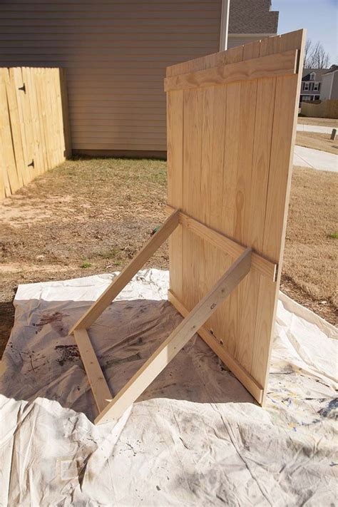 a piece of wood sitting on top of a sheet of plastic next to a building