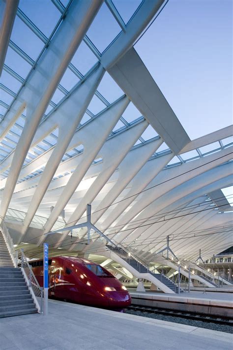 a red train traveling down tracks next to a loading platform