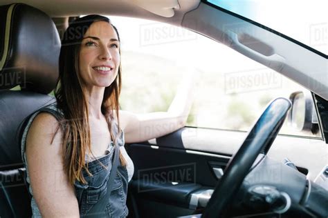 Smiling woman driving car - Stock Photo - Dissolve