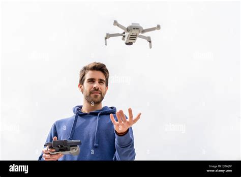 Young man operating a flying drone outdoors Stock Photo - Alamy