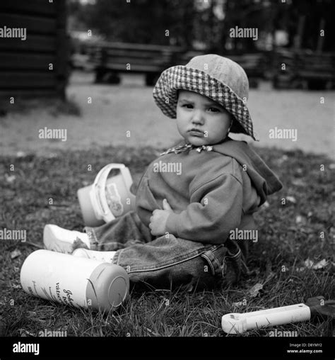 Baby sitting on grass and playing Stock Photo - Alamy