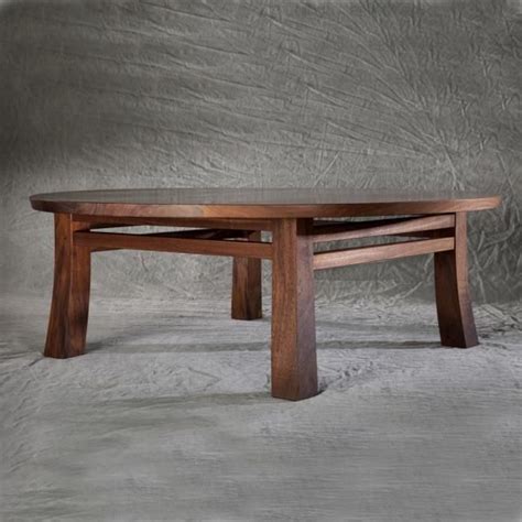 a wooden table sitting on top of a white floor next to a gray wall in a ...