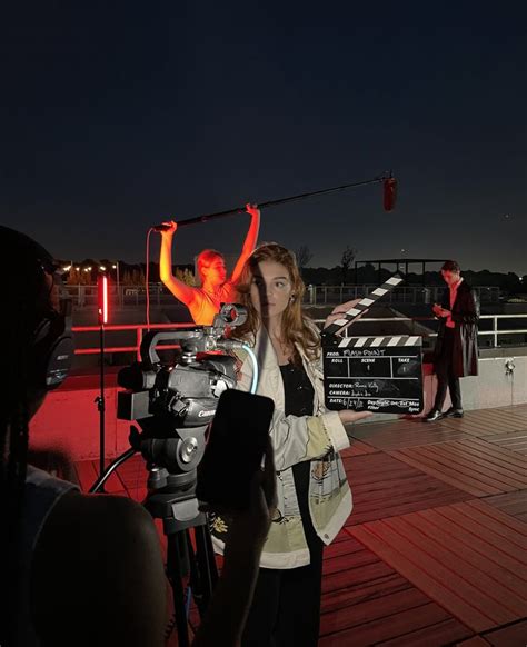 a woman standing on top of a wooden deck next to a camera