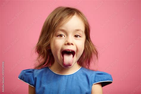 Isolated portrait of kid girl with wide open mouth and protruding tongue. Stock Photo | Adobe Stock