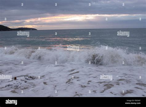 Waves crashing onto Gyllyngvase Beach, Falmouth at sunrise Stock Photo - Alamy