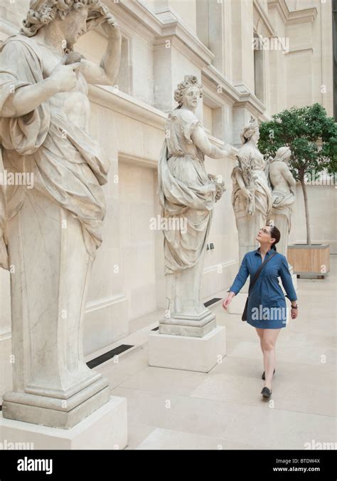 Woman looking at sculptures at the Louvre museum in Paris France Stock Photo - Alamy