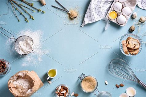 an overhead view of baking ingredients and utensils on a blue background