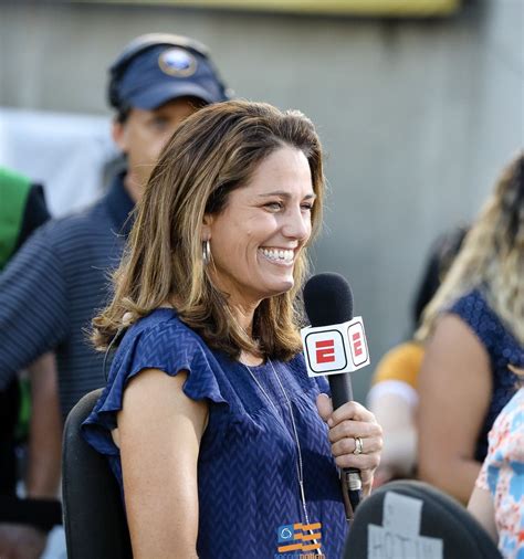 a smiling woman holding a microphone in front of a group of people on ...