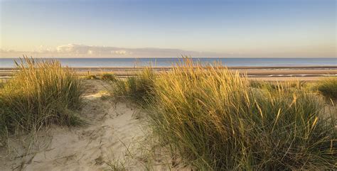 Beautiful sunrise over sand dunes system on yellow sand golden b ...