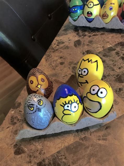 five painted eggs with faces on them sitting on a counter top next to each other