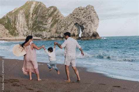 Family Holding Hands Together With Child On Beach Near Ocean in summer Stock Photo | Adobe Stock