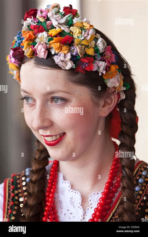 Poland, Cracow. Polish girl in traditional dress preparing to dance in ...