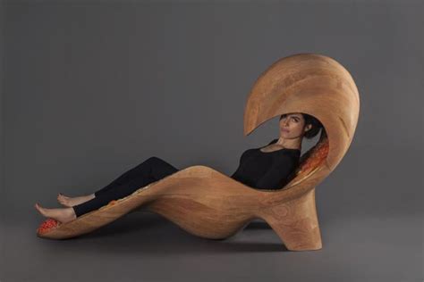 a woman is sitting in a wooden chair