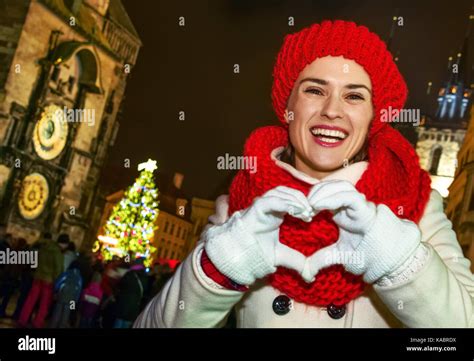 Magic on streets of the old town at Christmas. smiling young tourist woman in red hat and scarf ...
