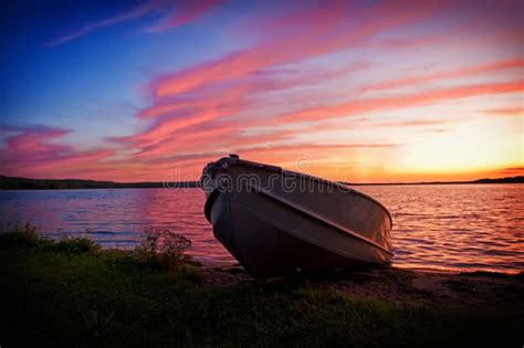 Image of Fishing Boat on Shore of Lake at Sunset Stock Photo - Image of green, lake: 12309574