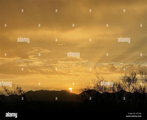 Golden dawn, sunrise peeking behind McDowell Mountains, spreading sun ...