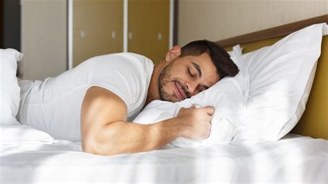 Young man peacefully sleeping in his bed – International Institute of Sleep