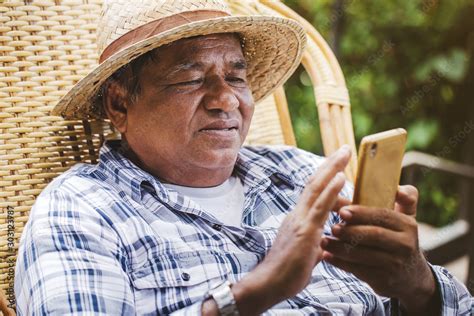 An elderly Asian man sitting using a mobile phone. Old man happy while ...