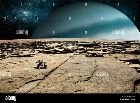 A rover explores the surface of a rocky and barren moon. A large ...