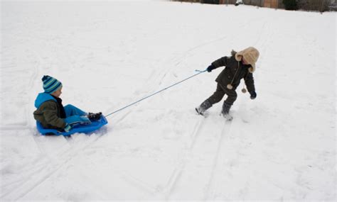 Boy Pulling His Friend On A Sledge Stock Photo - Download Image Now - Child, Snow, Sled - iStock