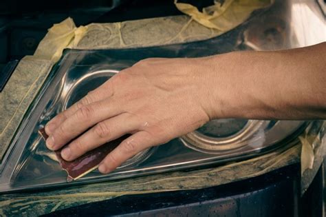 Premium Photo | Cleaning car headlights. the master cleans the headlights with fine sandpaper.