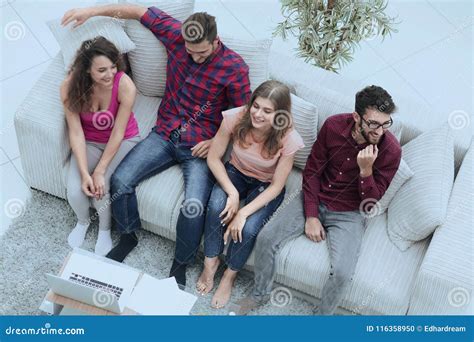 Triumphant Group of Friends Laughing while Sitting on the Couch in the Living Room Stock Photo ...