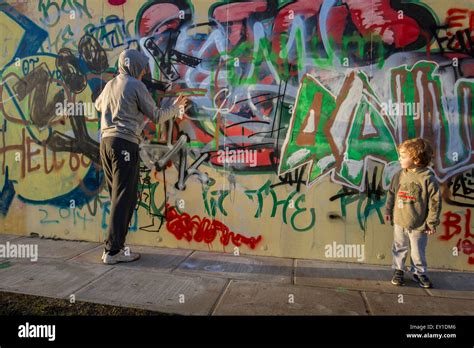 bad influence spray can graffiti with teen and boy Stock Photo - Alamy