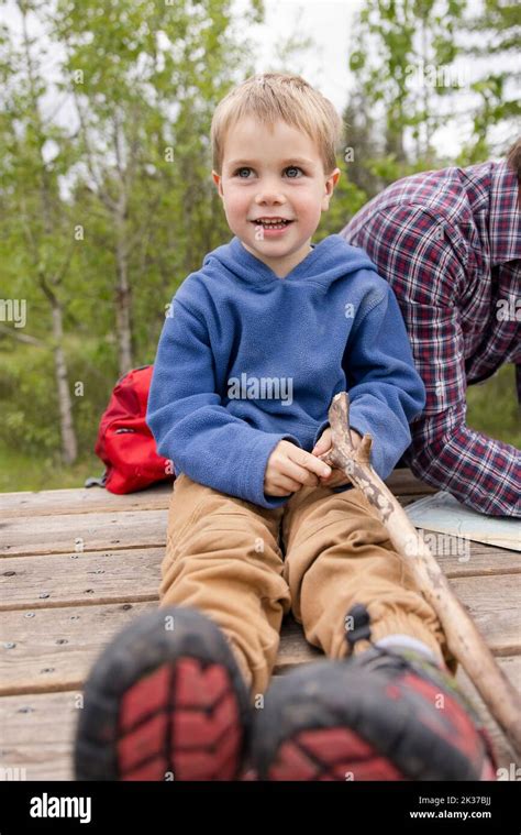 Boy sitting on picnic table Stock Photo - Alamy