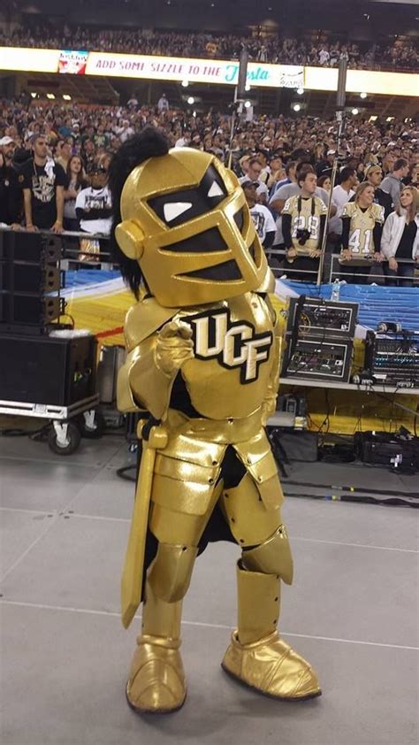 a man dressed as a robot standing in front of a crowd at a football game