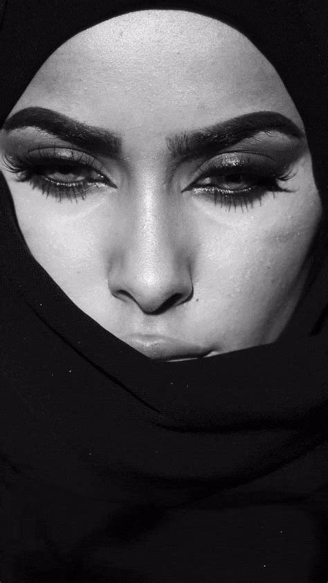 a woman wearing a black hijab with her eyes covered in dark makeup and ...