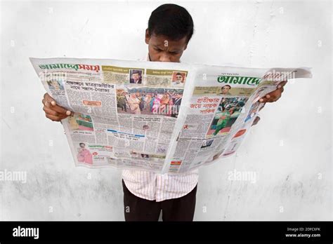 Bangladesh, Dhaka, man reads newspaper in Bengali language Stock Photo ...