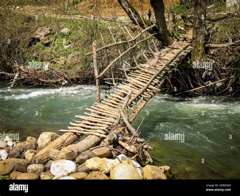 Wooden old bridge across a river. Wooden bridge with a railing on the ...