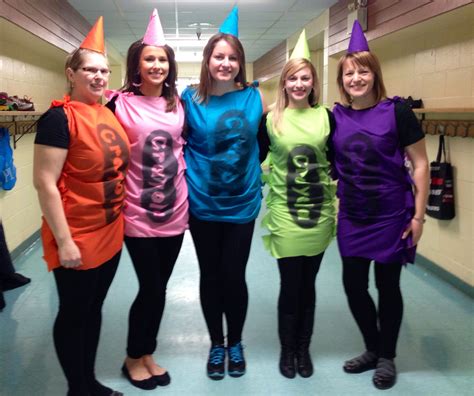 four women in costumes posing for the camera with one wearing a number on her shirt