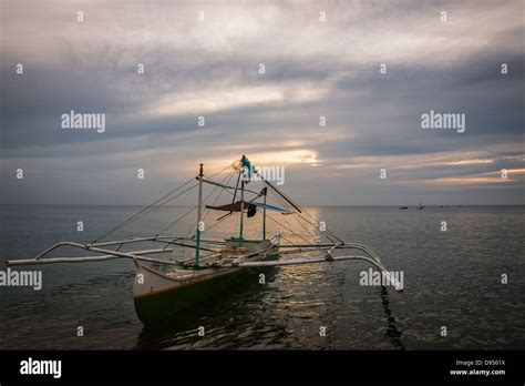 Bangka - a traditional Filipino fishing boat - moored for the day at Sugar beach, Sipalay on ...