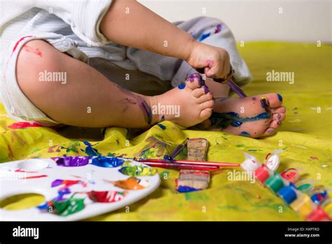 Little child painting feet using colorful paints Stock Photo - Alamy