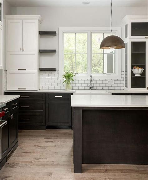 Two toned kitchen with white upper cabinets and dark stained lower cabinets The upper cabin ...