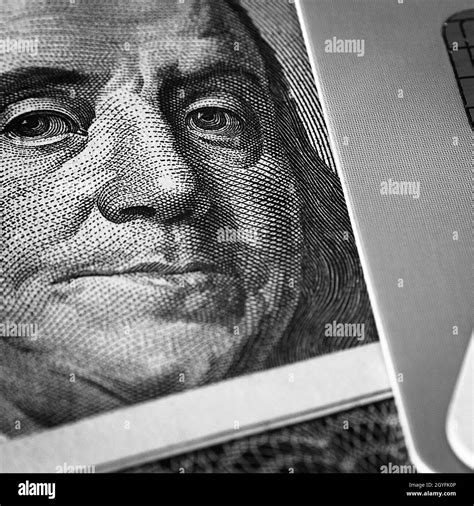 Benjamin Franklin's face on a hundred-dollar bill next to a credit card ...