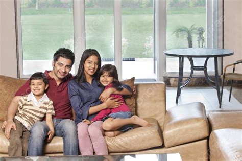 Portrait Of Happy Indian Family Of Four Sitting Together On Sofa Photo Background And Picture ...