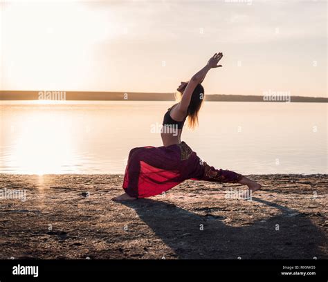 Silhouette yoga woman on the beach at sunset Stock Photo - Alamy