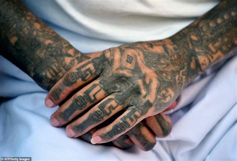 Former gang members in an El Salvadorian prison cross through their ...