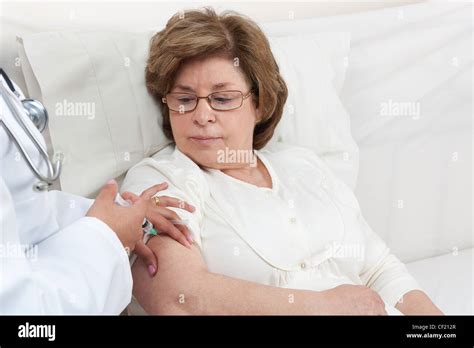 Doctor giving an injection onto a Senior Patient Arm Stock Photo - Alamy