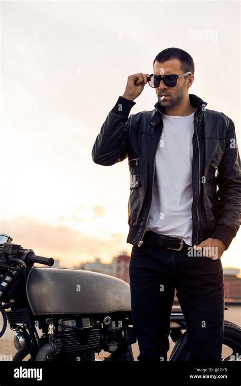 Closeup of a handsome rider guy with beard and mustache in black biker ...