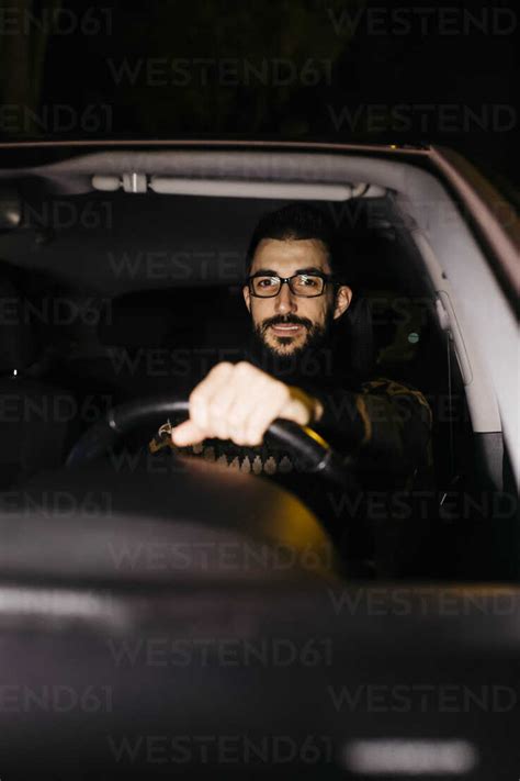 Portrait of confident man driving car at night stock photo