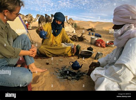 Algeria Djanet Tourist woman having tea with Tuareg people Sahara ...