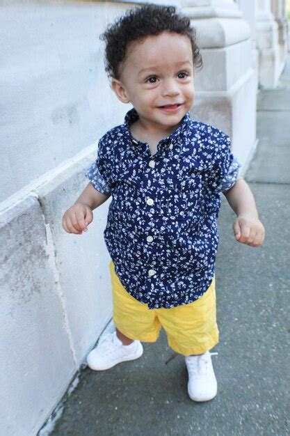 Premium Photo | Portrait of a smiling toddler standing outdoors