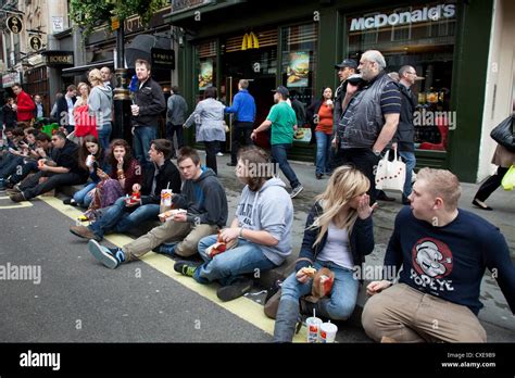 Young people eating McDonalds fast food on the street in London Stock ...