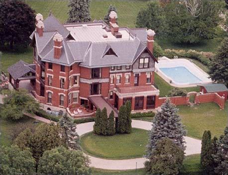 an aerial view of a large red brick house with a swimming pool in the yard