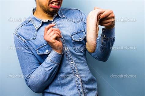 Squeamish man holding a raw ox tongue — Stock Photo © lofilolo #27089049