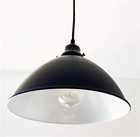 a black and white light hanging from a ceiling